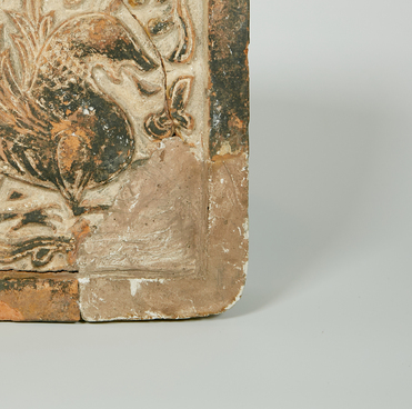 Red glazed tile with an image of a griffin